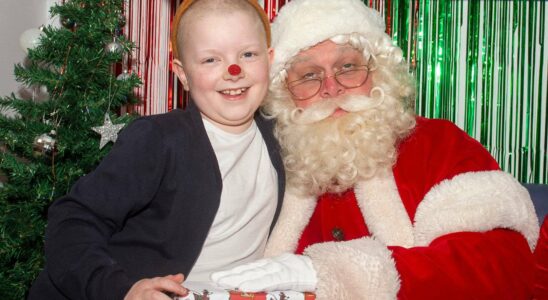 Visite émouvante du Père Noël à une fillette de 8 ans qui offre un cadeau spécial, emballé dans un papier créé pour soutenir des enfants malades.