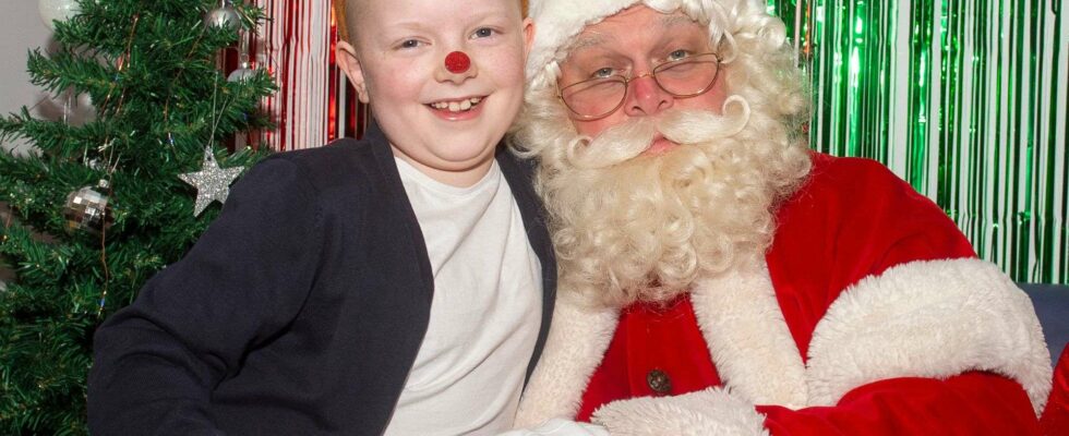 Visite émouvante du Père Noël à une fillette de 8 ans qui offre un cadeau spécial, emballé dans un papier créé pour soutenir des enfants malades.